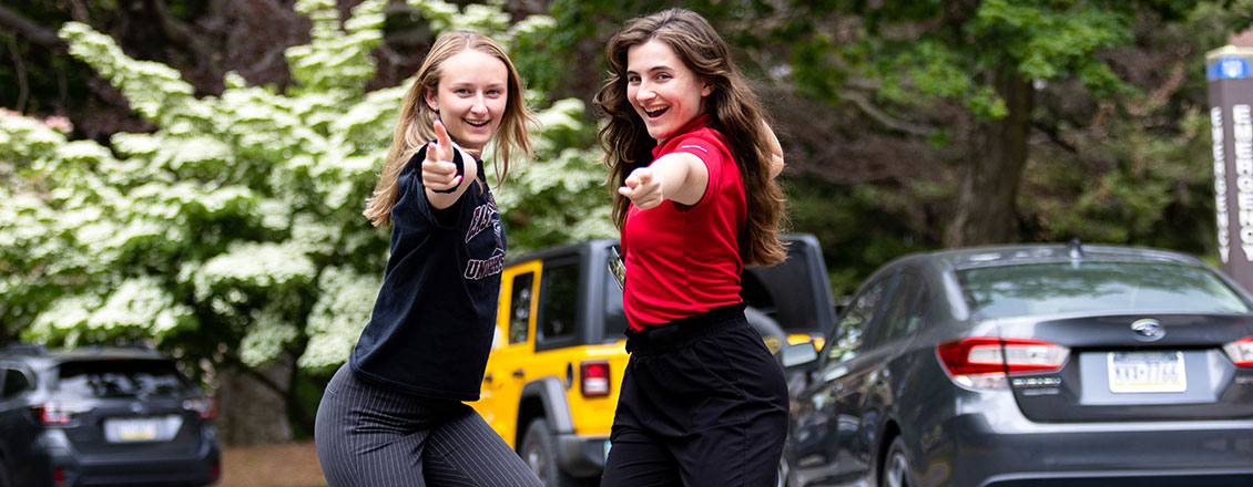 two female students giving thumbs up
