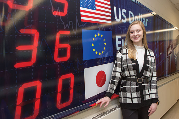 Female student in front of a Wall St. sign