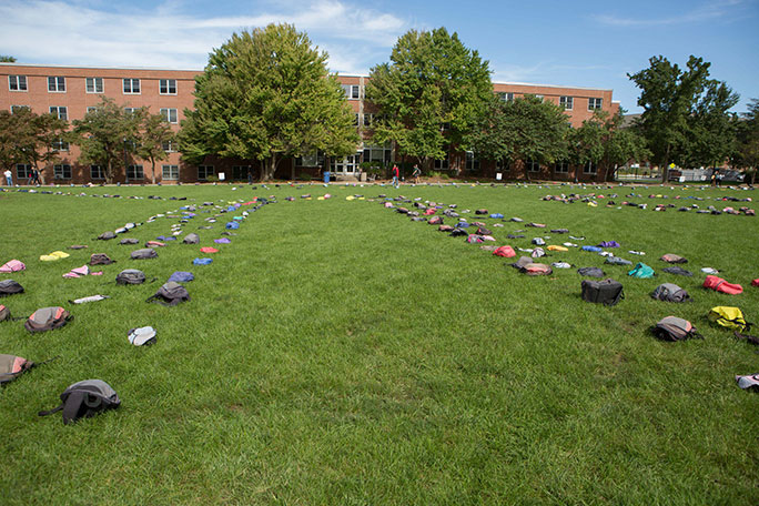 Backpacks laying on the grass as part of Send Silence Packing.