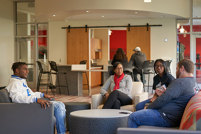 Students sitting on couches in a residence hall loungue