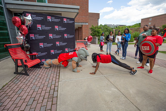 Warrior mascot doing push-ups with student during orientation