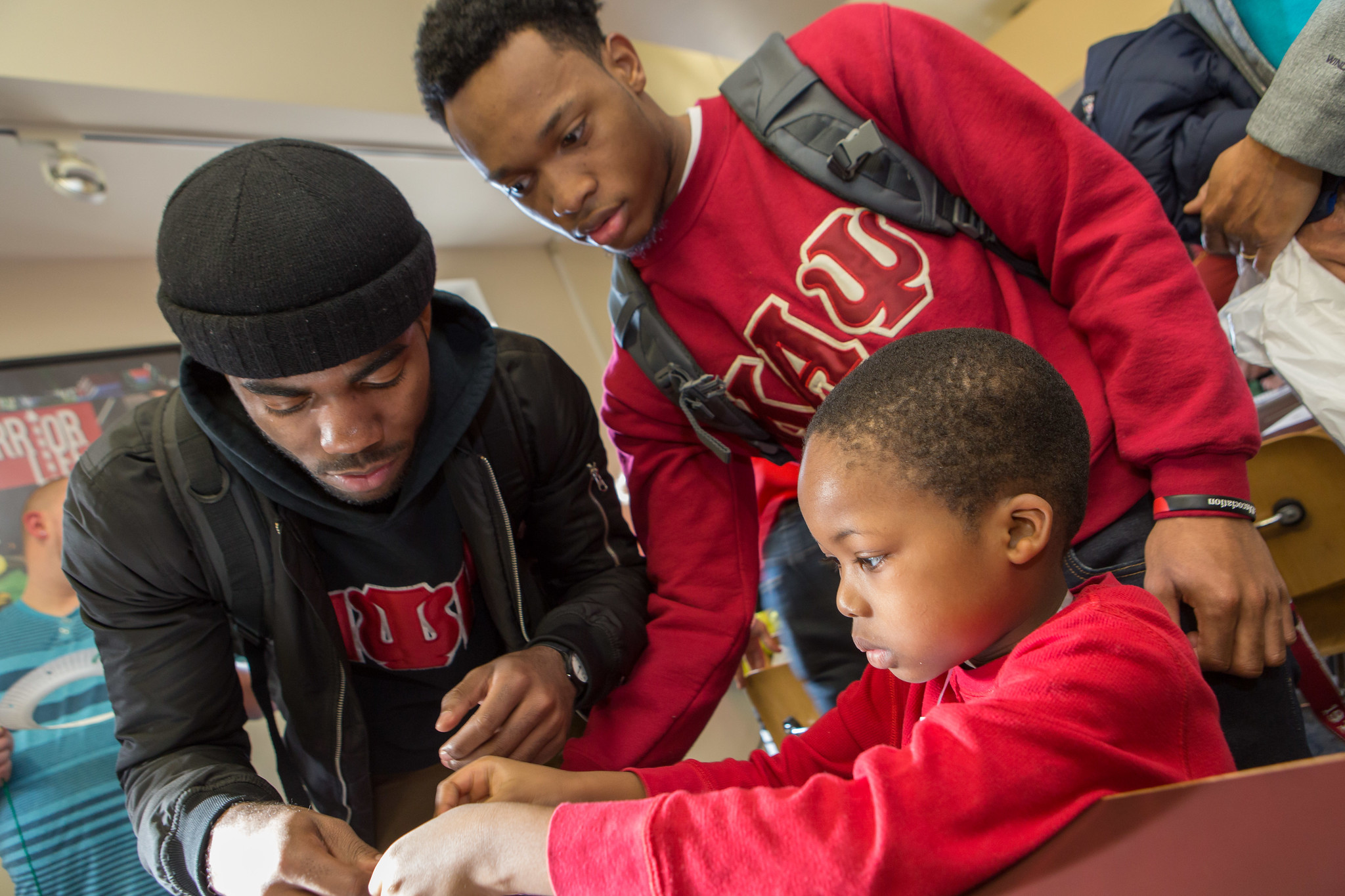 Two ESU fraternity students helping an young child