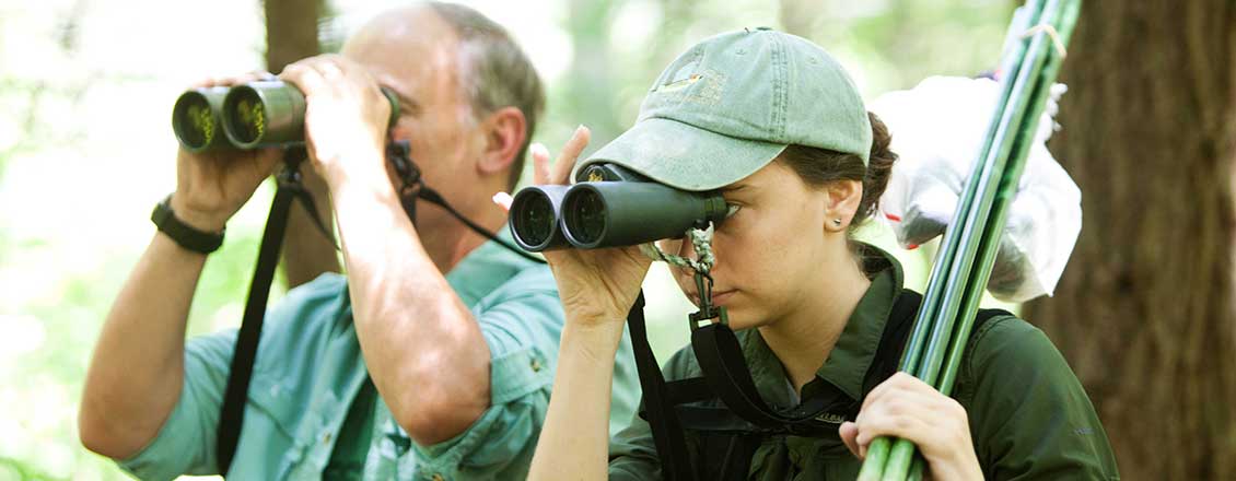 Teacher and student looking for birds using binoculars