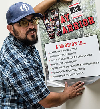 Jared Hildabrant holding a Way of the Warrior sign contianing the seven tenets listed above