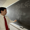 professor writing on chalkboard
