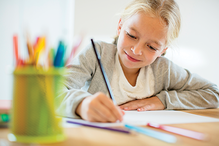 Children drawing with a colored pencil