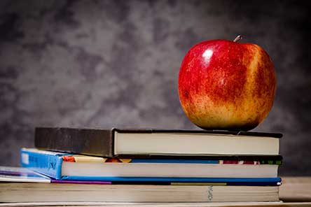 An apple on top of school textbooks