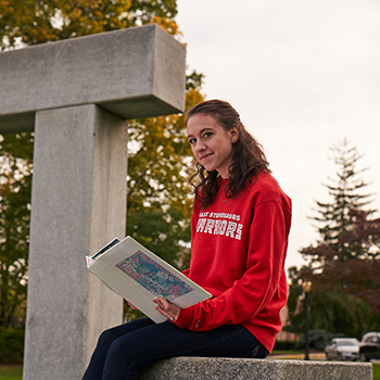 Student sitting near Stroud Hedge