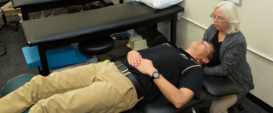 Dr. Kelly Harrison applying manual therapy to a patient’s neck.