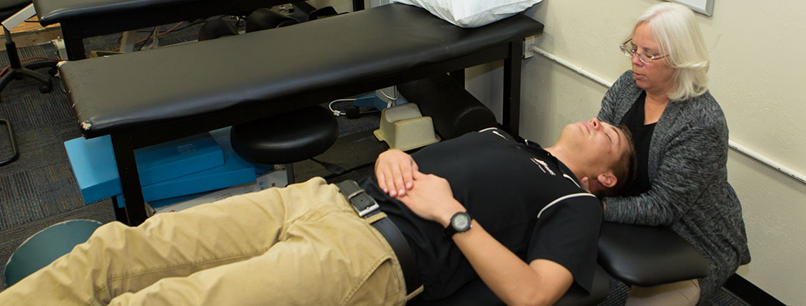 Dr. Kelly Harrison applying manual therapy to a patient’s neck.