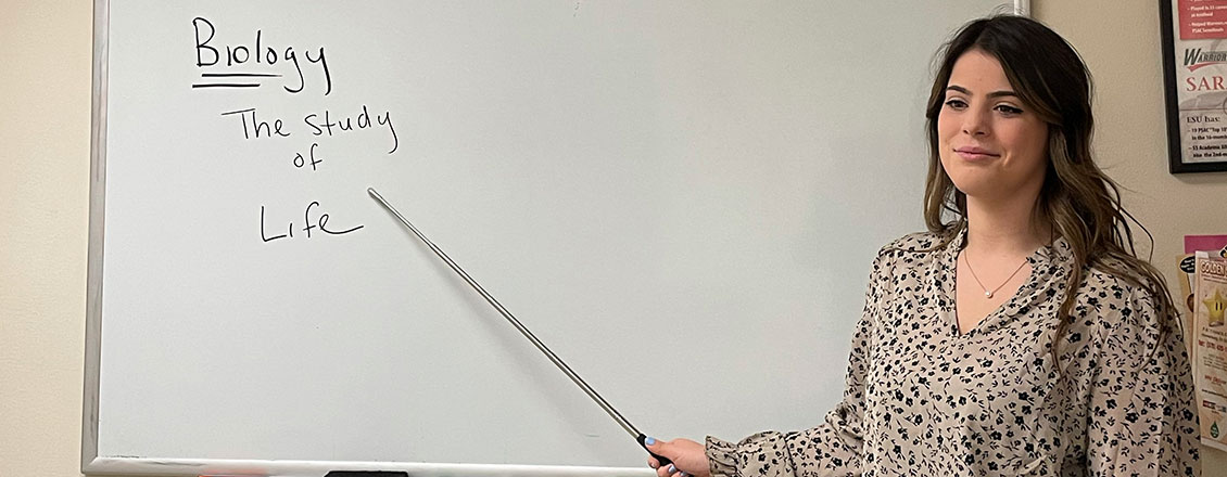 student teacher pointing to white board