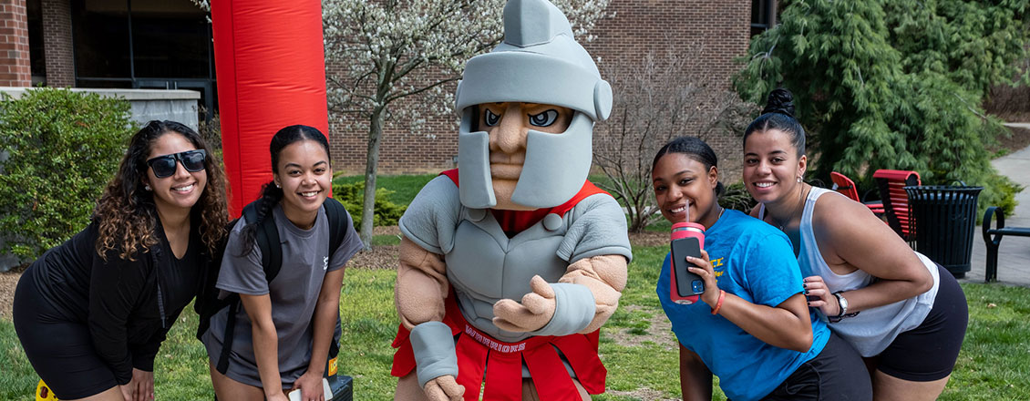 students posing with mascot
