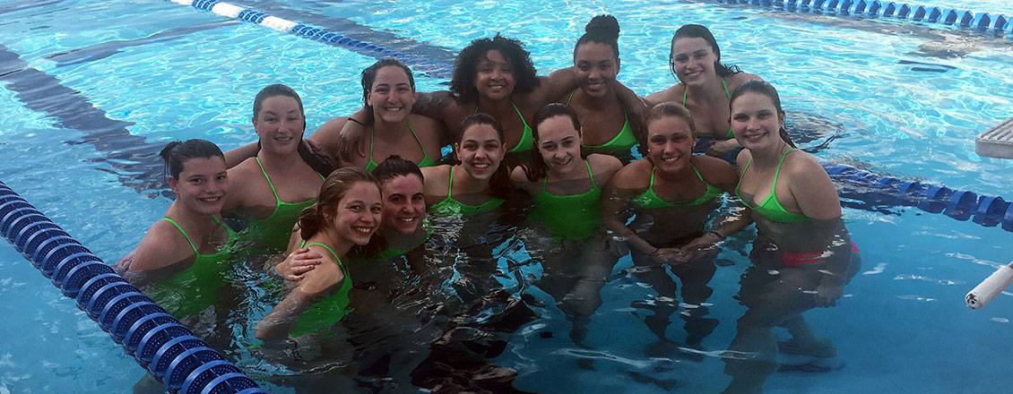 The swim team posing in a pool