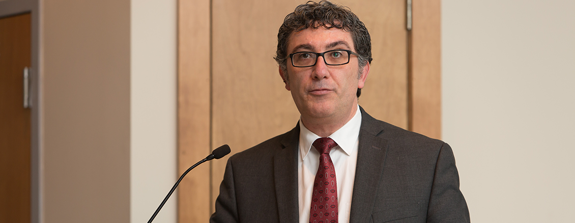 Professor Cem Zeytinoglu speaking at podium