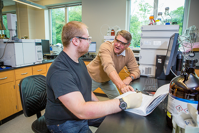 Professor Kelly speaking with student in lab