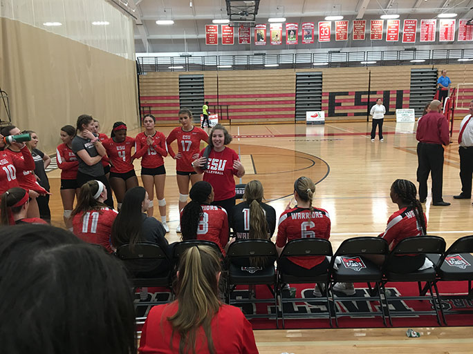 female students stnading on court during volleyball game