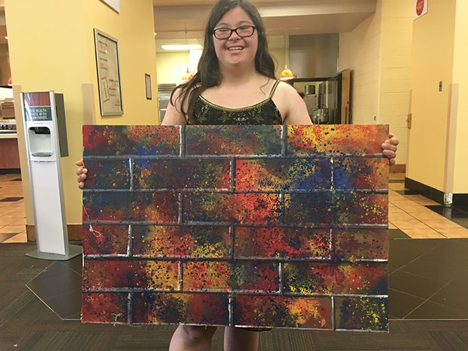 female student holding painting