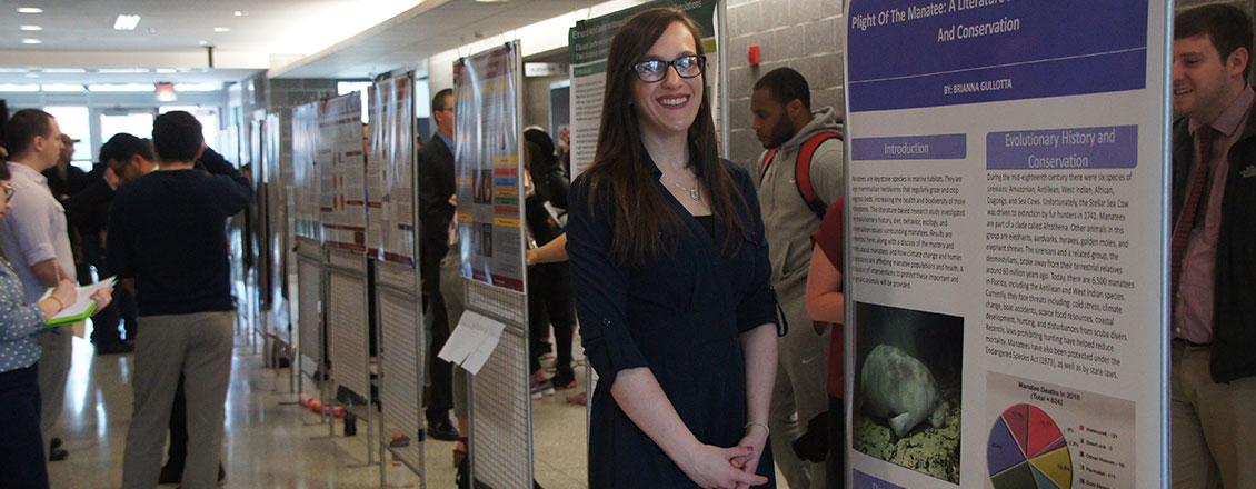 Student standing in front of research project