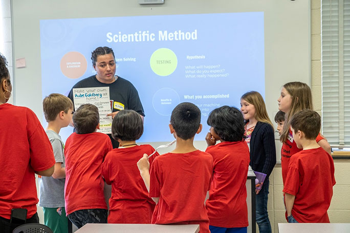 teacher showing students a poster