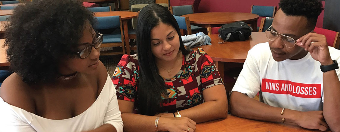 three students sitting at table