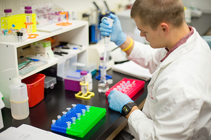 A student in a lab conducting DNA extraction