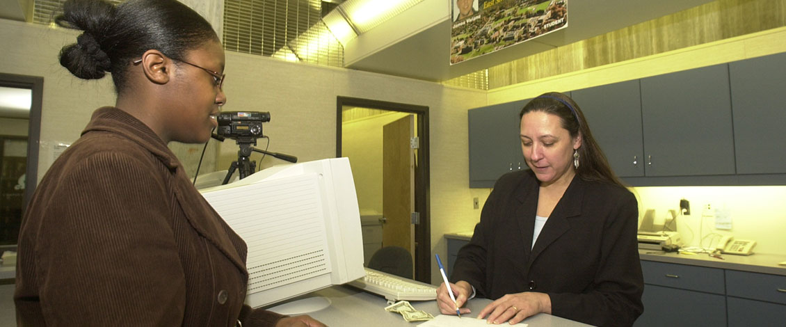 Student in Campus eCard Center getting help from staff