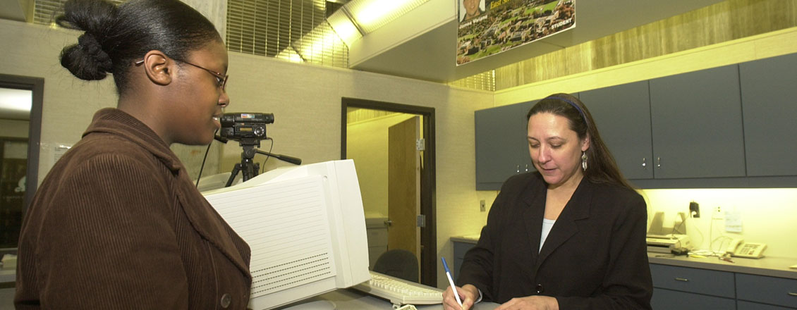 Student in Campus eCard Center getting help from staff