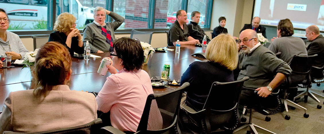 Adults conversing around a conference table