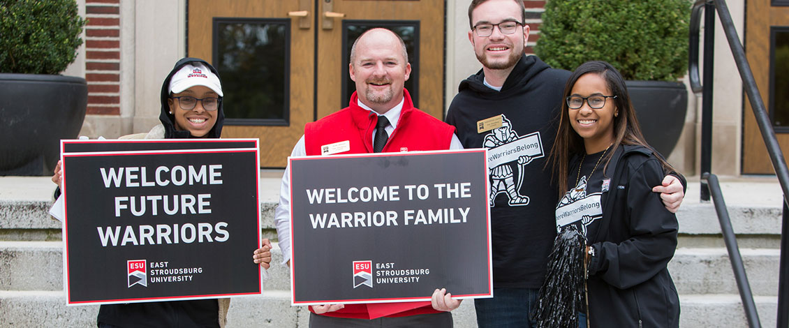 Students and staff welcoming families to an Open House