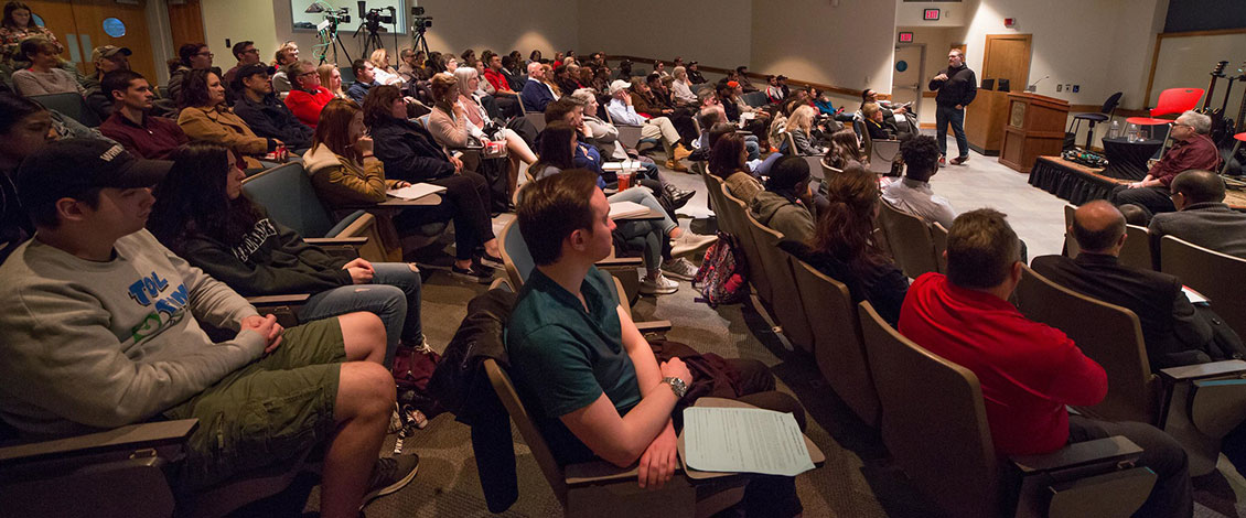 Students in an audience listening to an entrepreneur