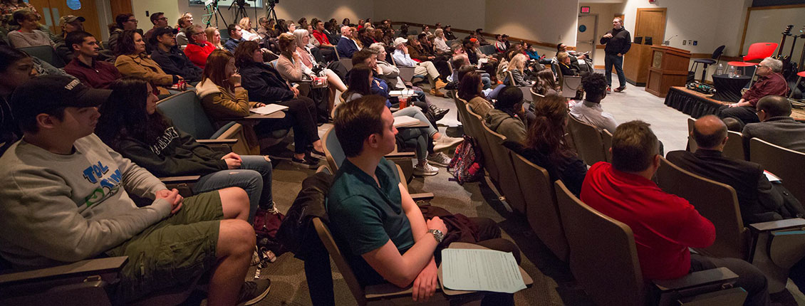 Students in an audience listening to an entrepreneur