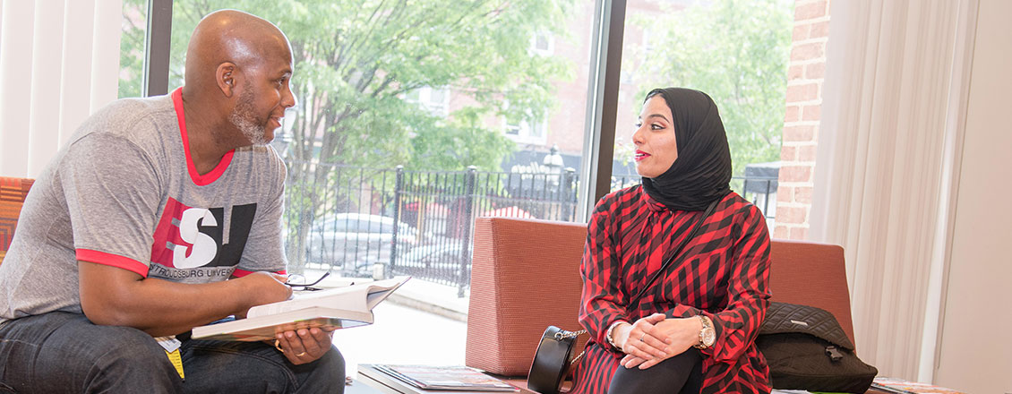 Students in lobby discussing a textbook