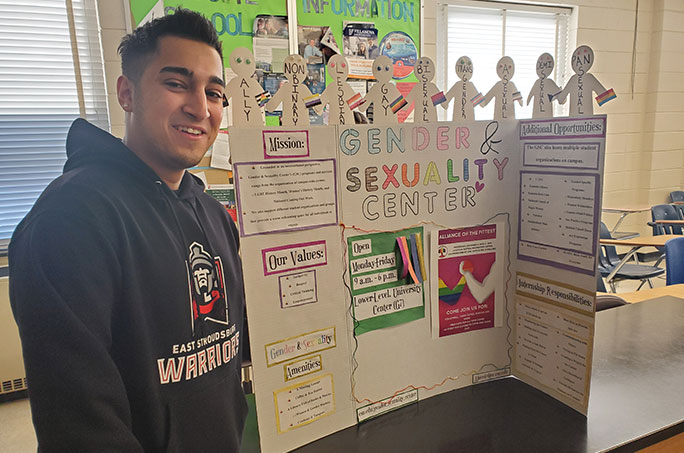 A student standing in front of a poster conference presentation