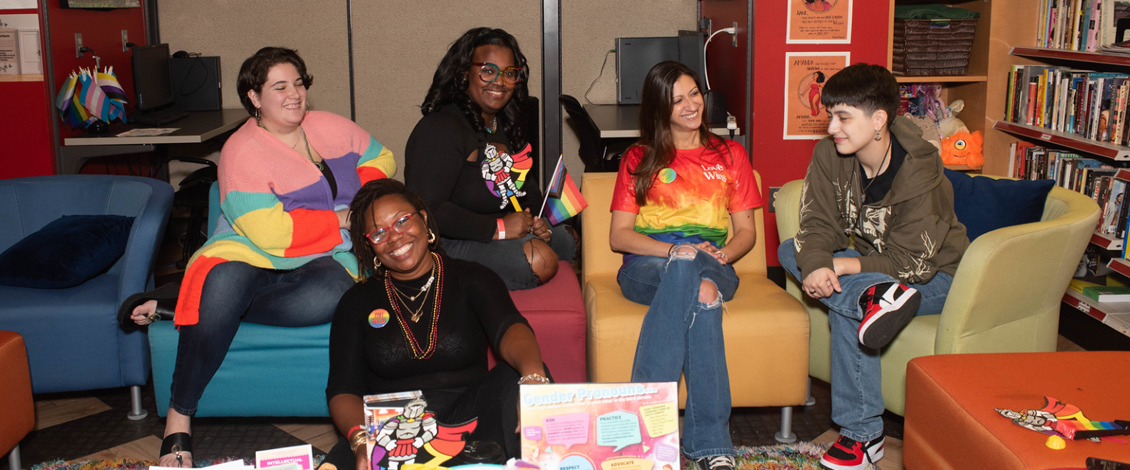 Five people sitting and talking in groups in the Gender and Sexuality Center