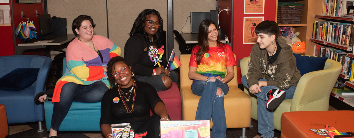 Five people sitting and talking in groups in the Gender and Sexuality Center