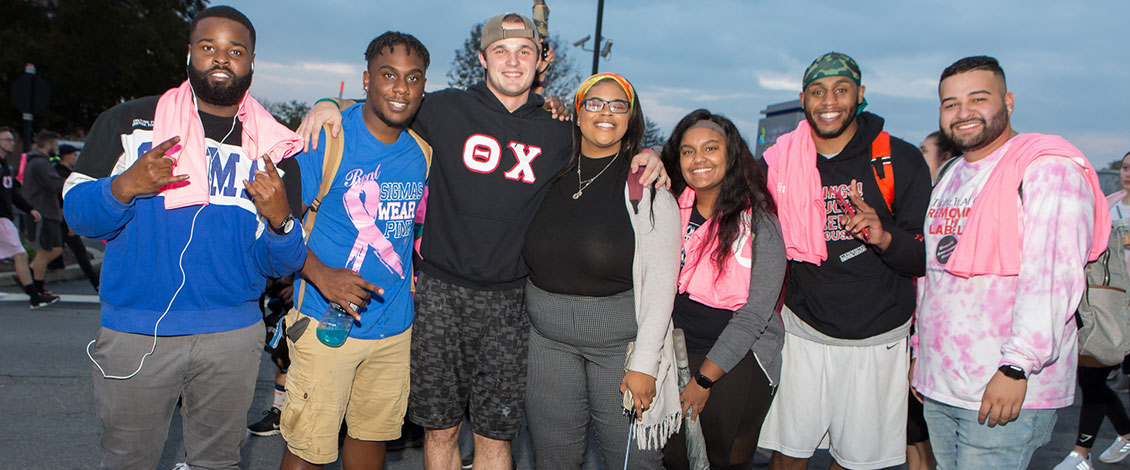 Students smiling together at the Pink Light Walk