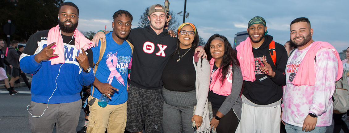 Students smiling together at the Pink Light Walk