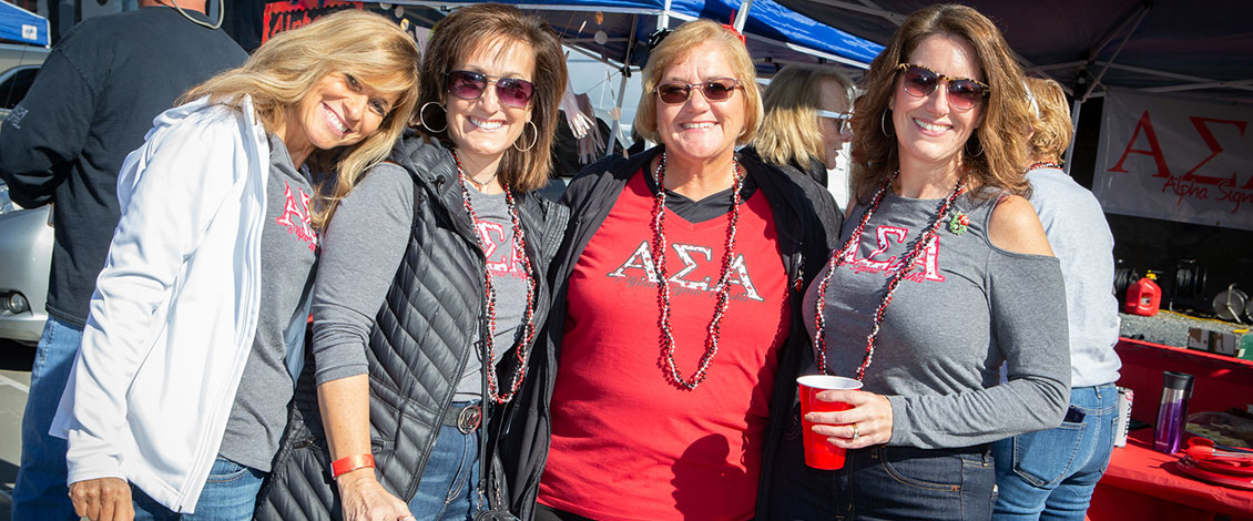 Four female alumni at the homecoming tailgate party