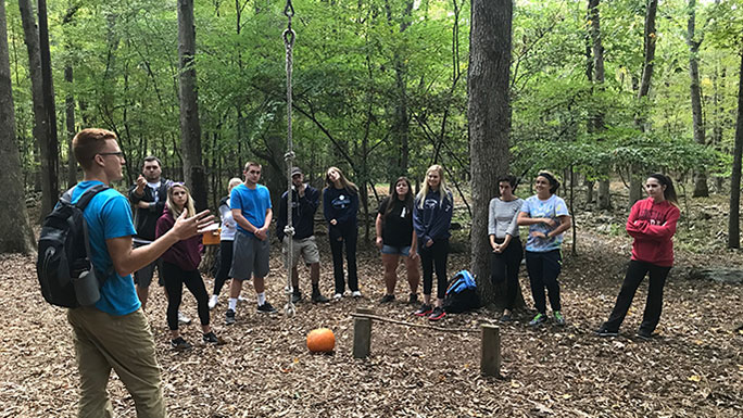 Students listening to an instructor in an outdoor nature area