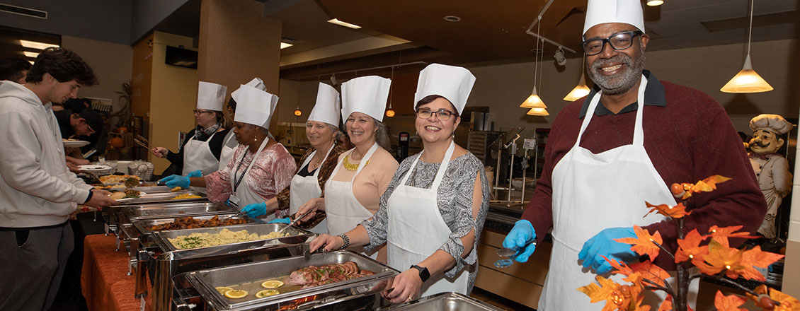 staff serving thanksgiving meal to students