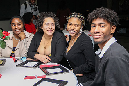 3 female and 1 male student sitting at table