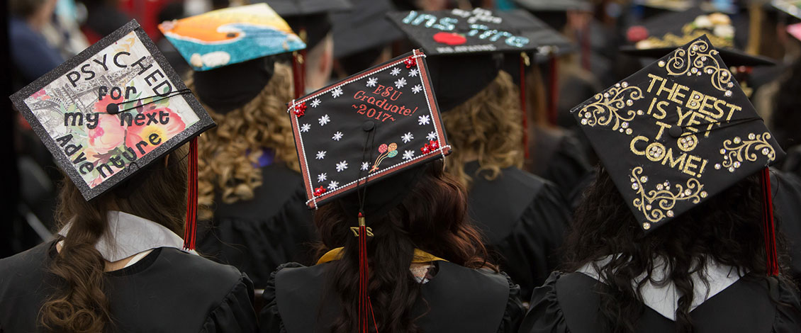 Students wearing decorated caps at commencement