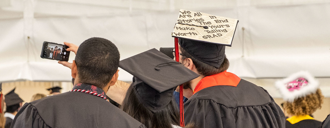 Students wearing decorated caps at commencement