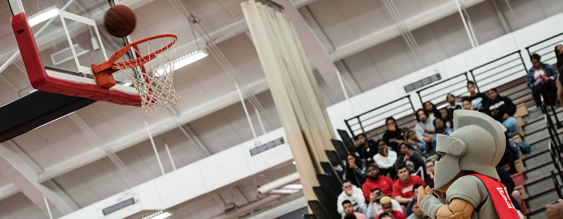 The Warrior mascot shooting a basket