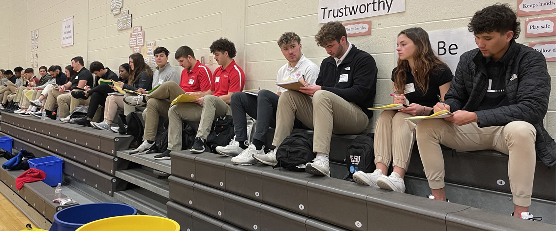 students sitting on the gym bench