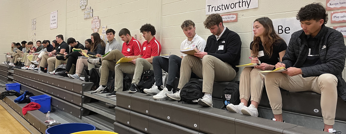 students sitting on the gym bench