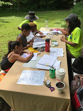 kids and teacher a picnic table writing