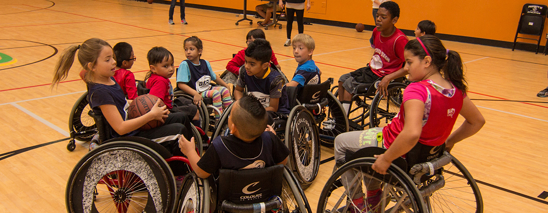 young kids in wheelchairs playing basketball
