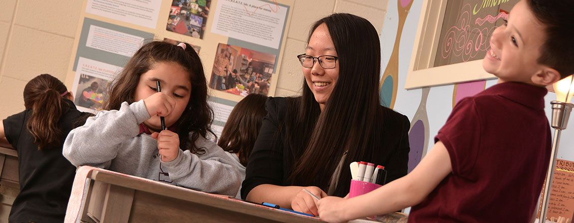 student teacher assisting first graders in the create lab