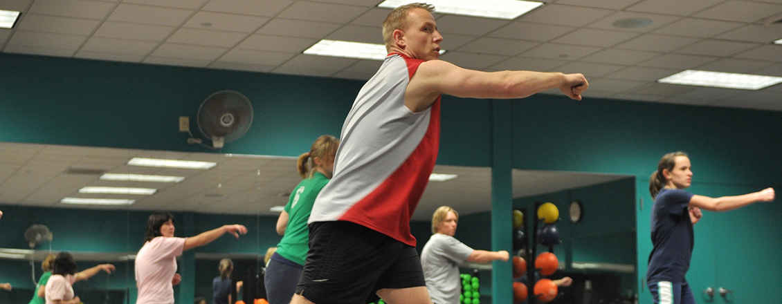 man teaching aerobic exercises to class